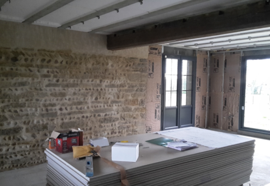 Chantier en préparation pour pose de placo sur murs et plafond dans ferme bressane avec mur en pierre